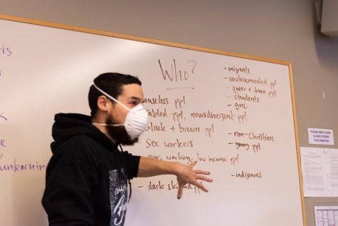 Person gesturing in front of a whiteboard.