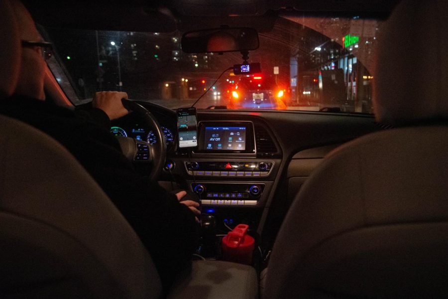 View of a Safe Ride driver’s car from the passenger seat showing the car’s dashboard and the driver’s view of the Safe Ride app.