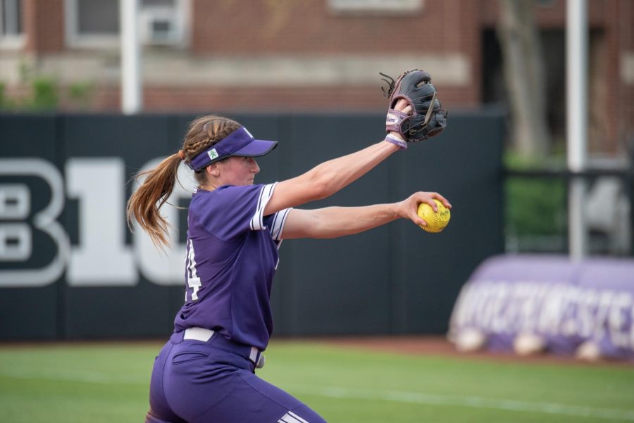 Girl in purple uniform throws softball