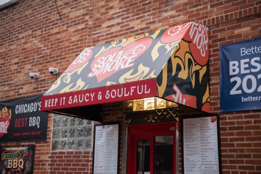 A red, black and orange awning connected to a brick building that reads “Soul & Smoke” and “Keep it saucy and soulful.”
