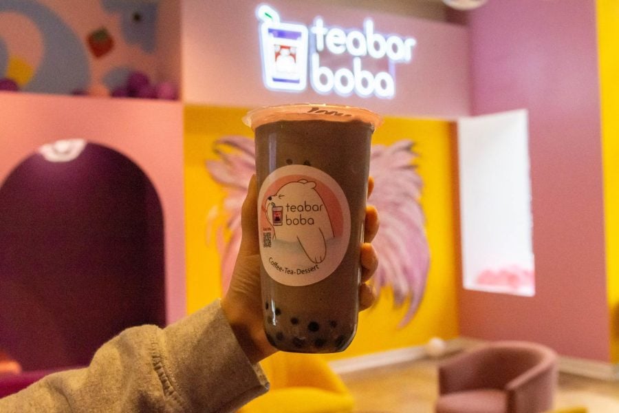 A milk tea with tapioca is located in front of a Teabar Boba sign.
