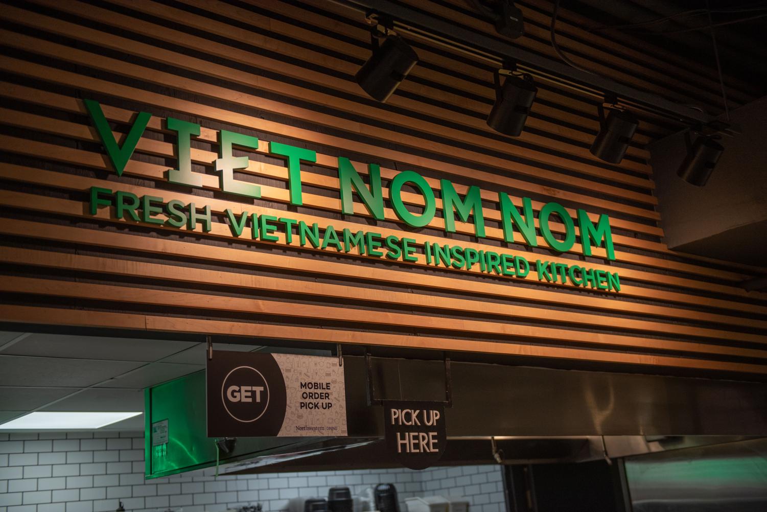 A+brown+sign+with+the+words+%E2%80%9CViet+Nom+Nom+Fresh+Vietnamese+Inspired+Kitchen%E2%80%9D+in+green.