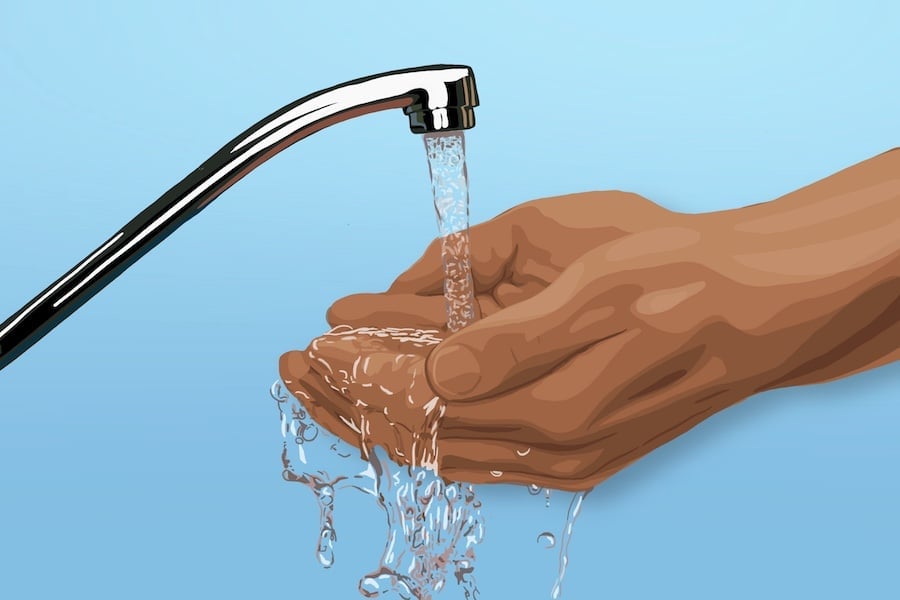 Water from a tap runs into a person’s hands