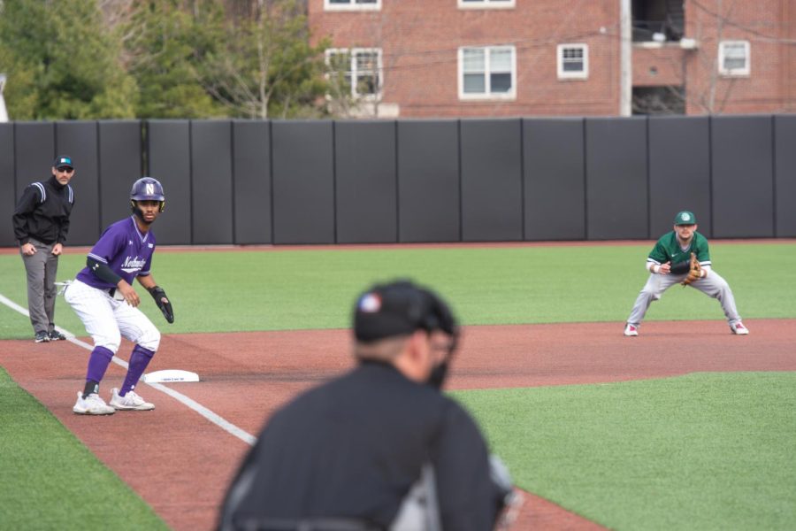 Player in purple watches the ball on base.