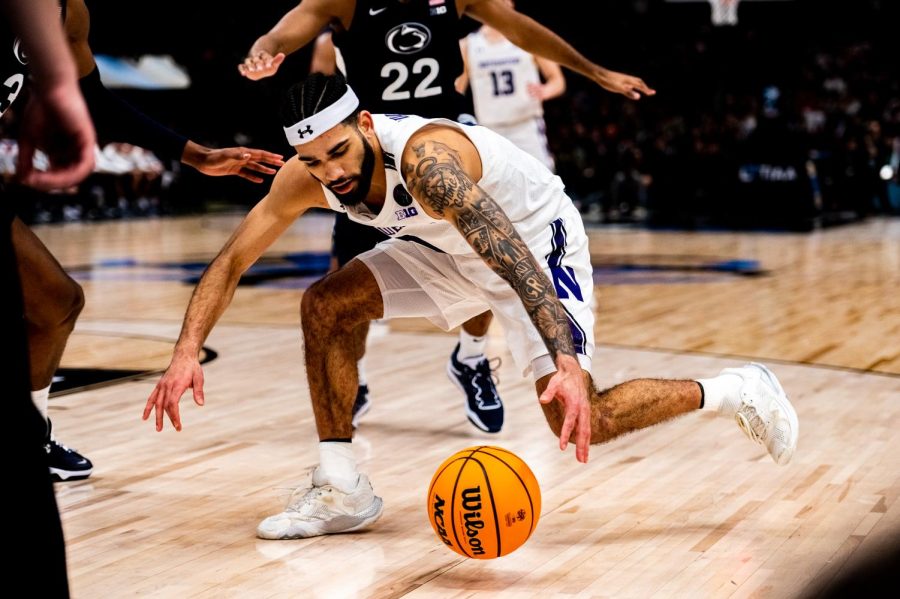 A player in white dribbles a basketball on the court.