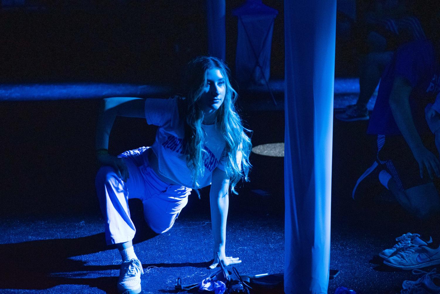A person is stretching under the blue light.