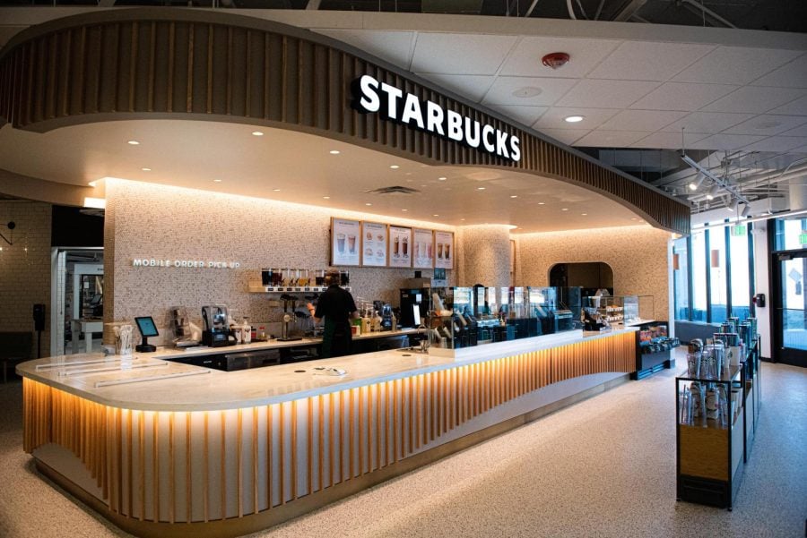 A Starbucks venue with white marbled tabletop and wooden panels underlying the counters.