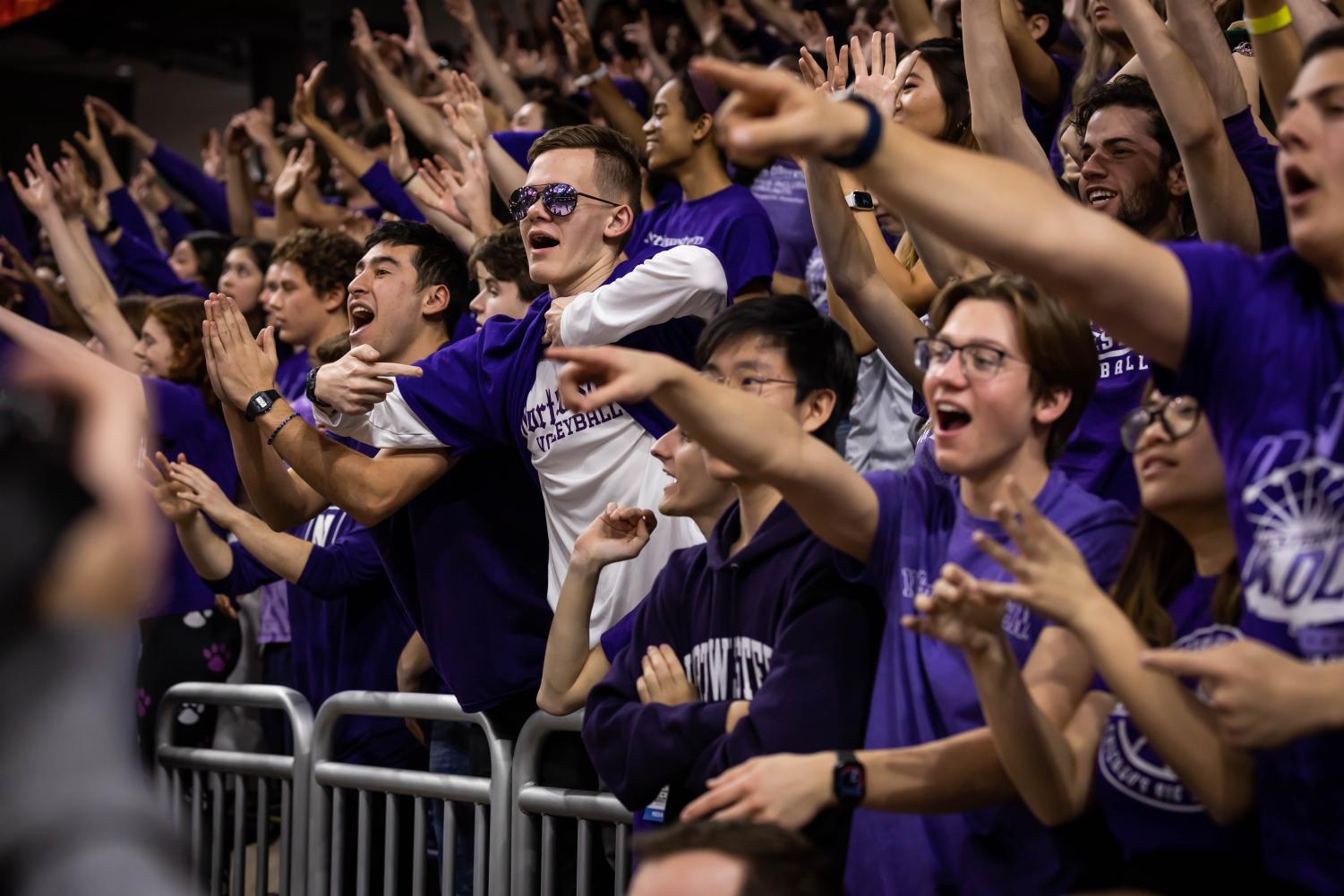 A crowd wearing purple reaches out to the basketball court.