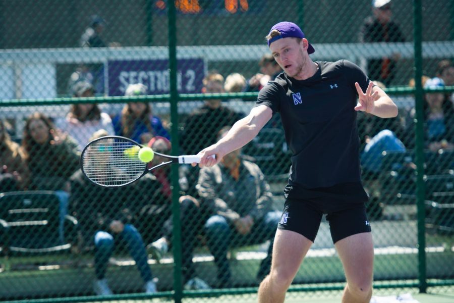 A player swings at a tennis ball coming to their right.