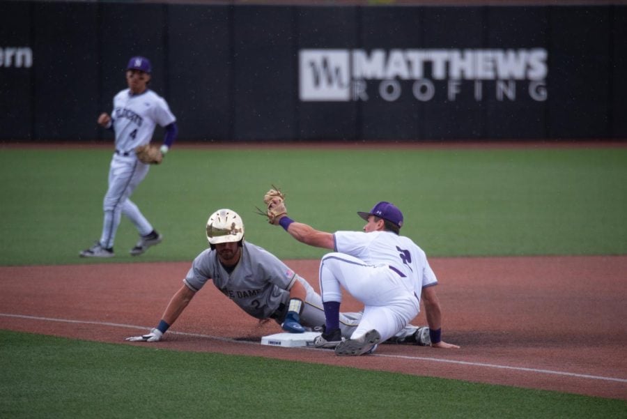 Player in white jersey tags out a runner.
