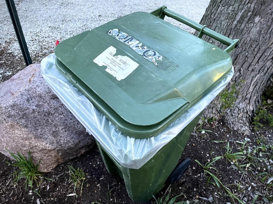 Green compost bin in front of a tree.
