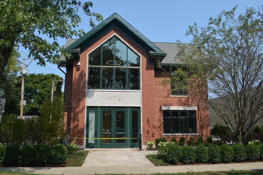 The Northwestern Hillel building, a red brick building with green trees around it.