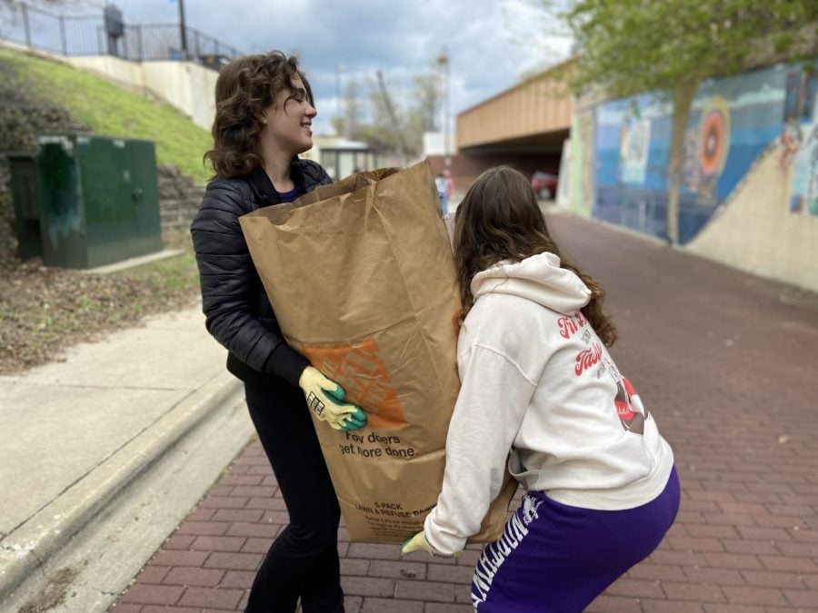 Two people lift a brown bag