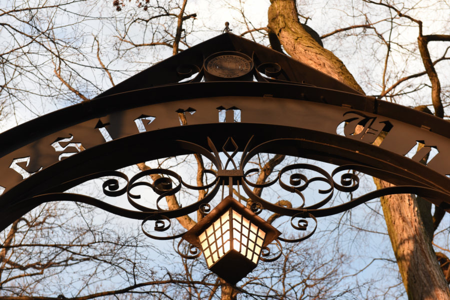 A close up of Weber Arch with a yellow lamp against leafless trees.