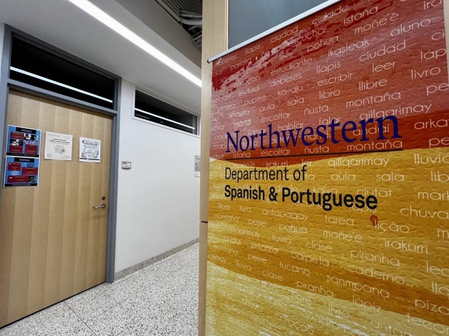 A red and yellow sign that reads ‘Northwestern Department of Spanish and Portuguese’ inside of the Kresge building.