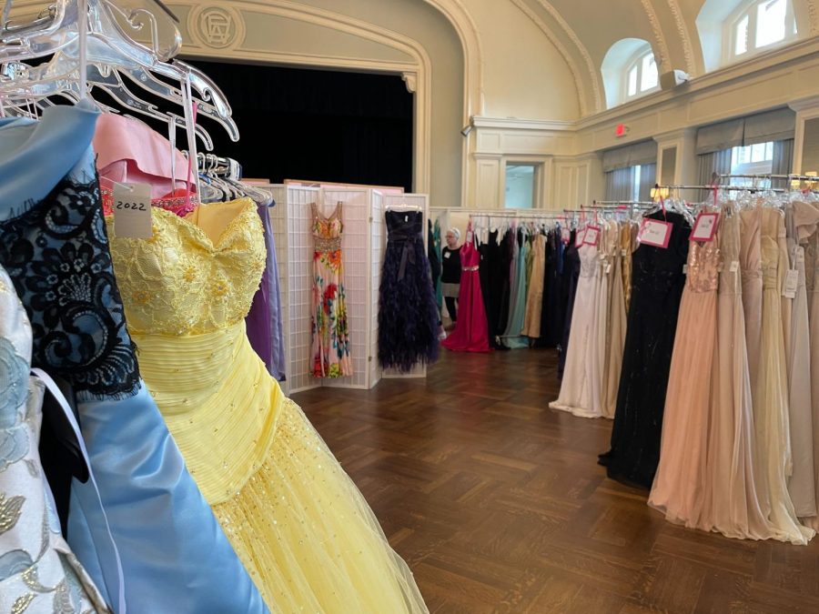 Racks of prom dresses hang in white ballroom at The Woman’s Club of Evanston.