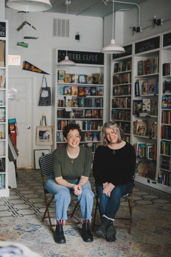two women sit in chairs in a bookstore