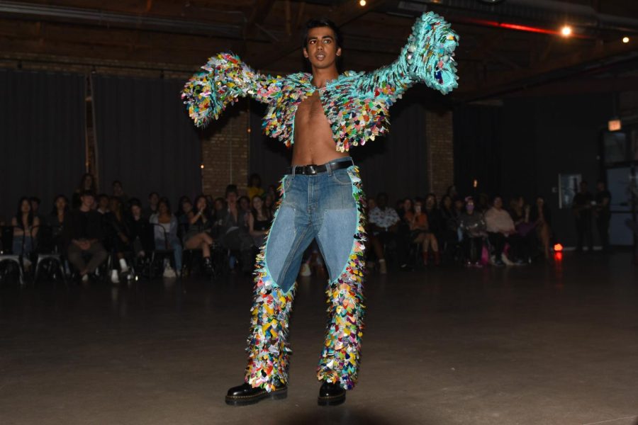 A model raises their arms to show off the brightly colored sequence on their sleeves.