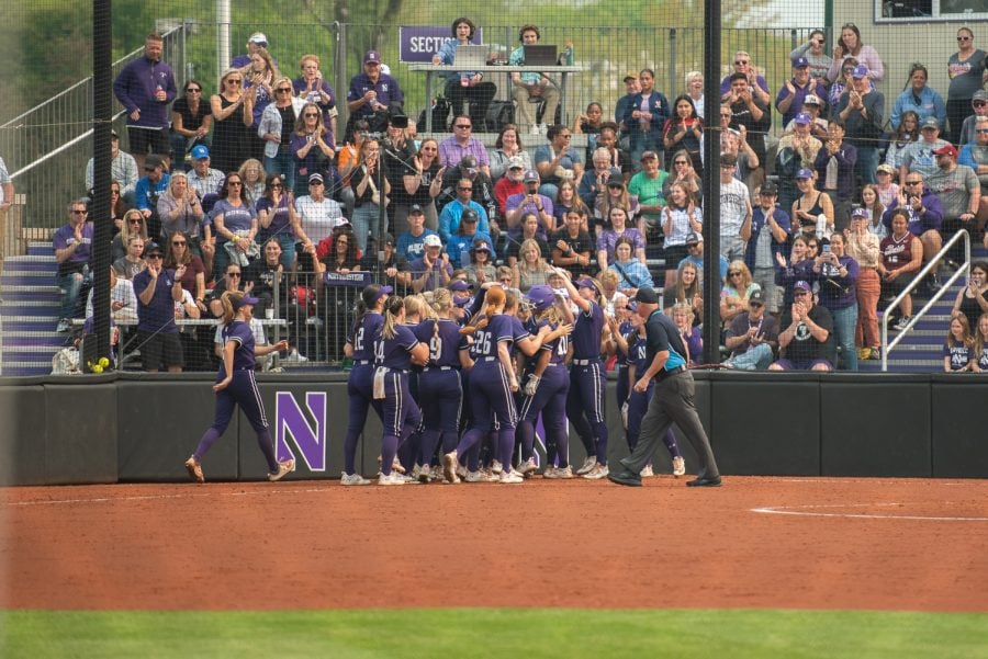 Players+in+purple+jerseys+celebrate+at+home+plate.