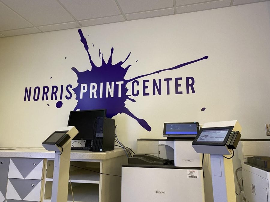 Printing station with purple splat, “Norris Print Center” written on the wall.