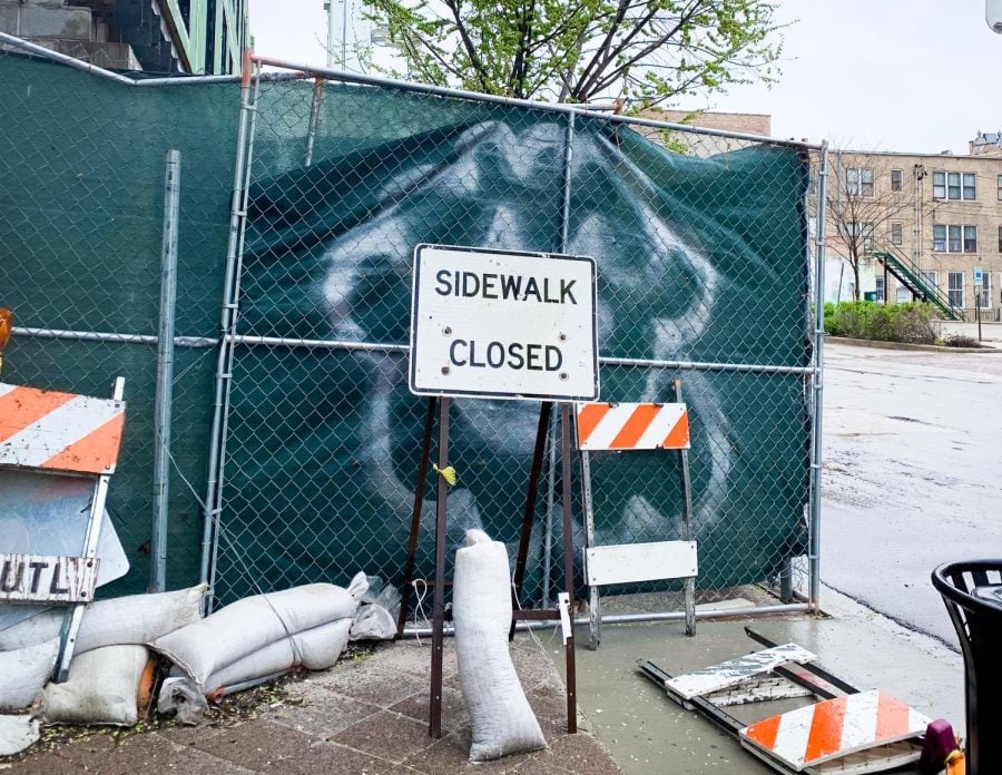 A “sidewalk closed” sign sits in front of fencing