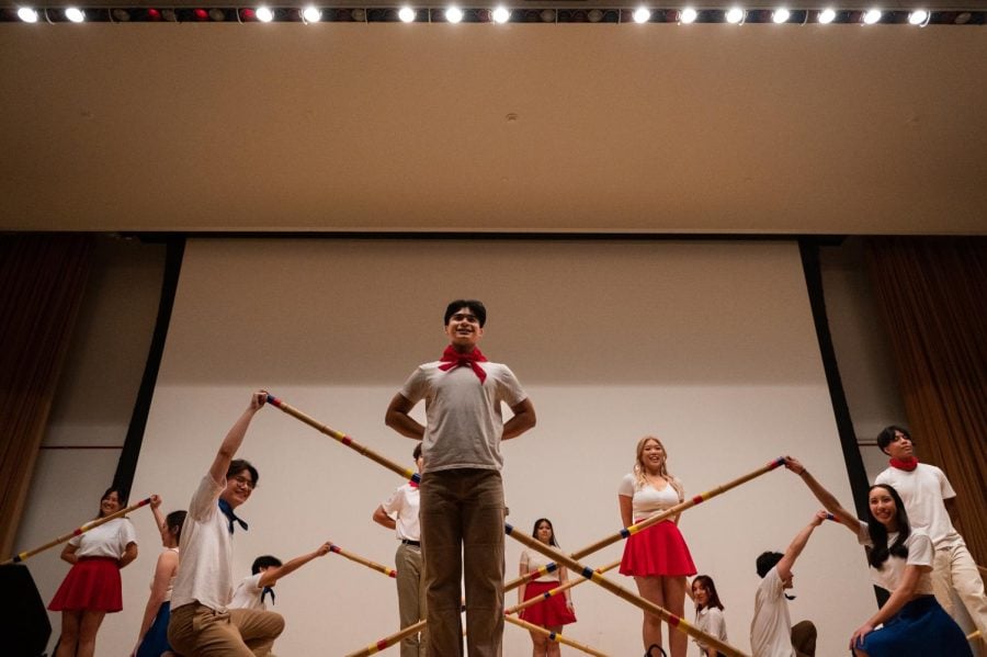 Student performers face the crowd as they dance Tinikling, a Philippine folk dance.