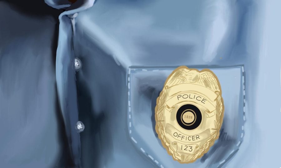A person wears a blue shirt with a police badge attached to the shirt pocket.