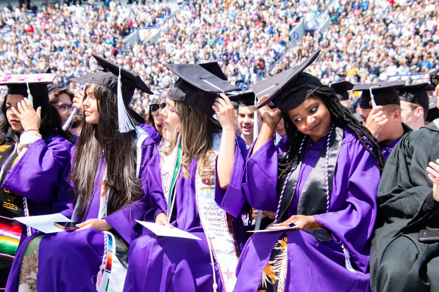 Students in purple robes move their tassel to the left side of their cap.