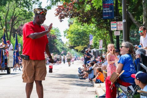 A man waves at a girl in the parade crowd.