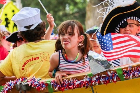 A girl sticks her tongue out from a yellow float.