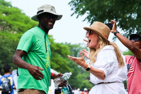 A man in a green shirt converses with a woman. 