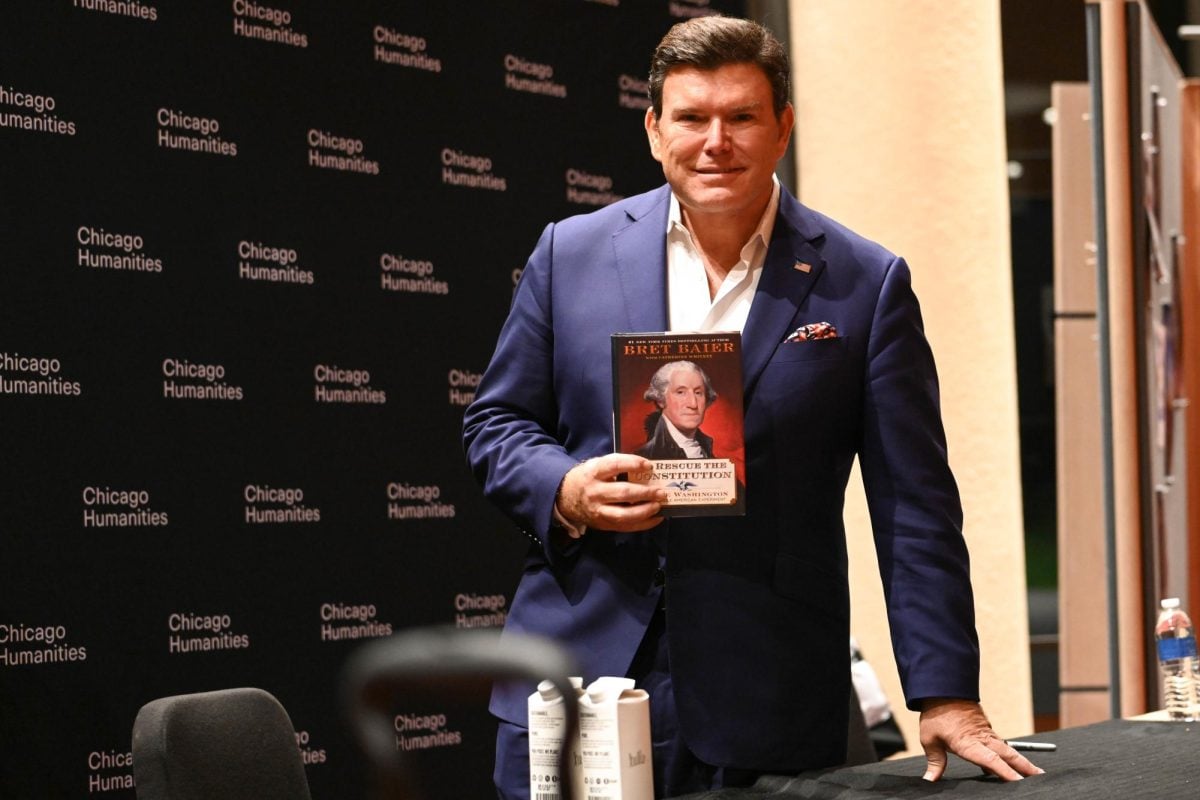 Fox News host Bret Baier poses with his new book, “To Rescue the Constitution,” after speaking at Pick-Staiger Concert Hall on Saturday.