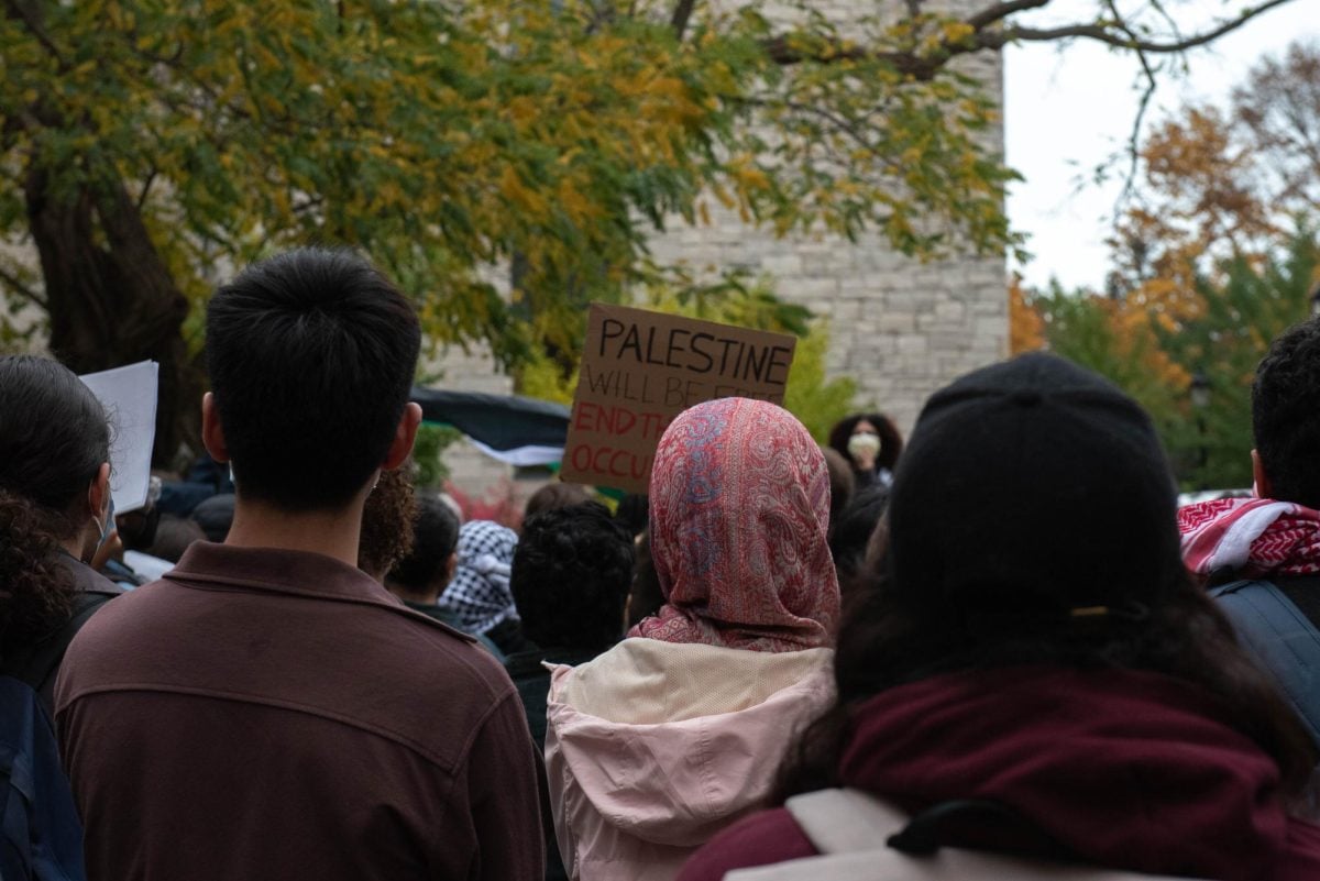 Students participating in the walkout campaign organized by NU’s chapter of Students for Justice in Palestine face The Rock. More than 150 people attended the protest condemning Northwestern’s response to the Israel-Hamas war.