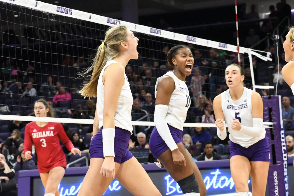 A player in a white and purple volleyball uniform screams in excitement.