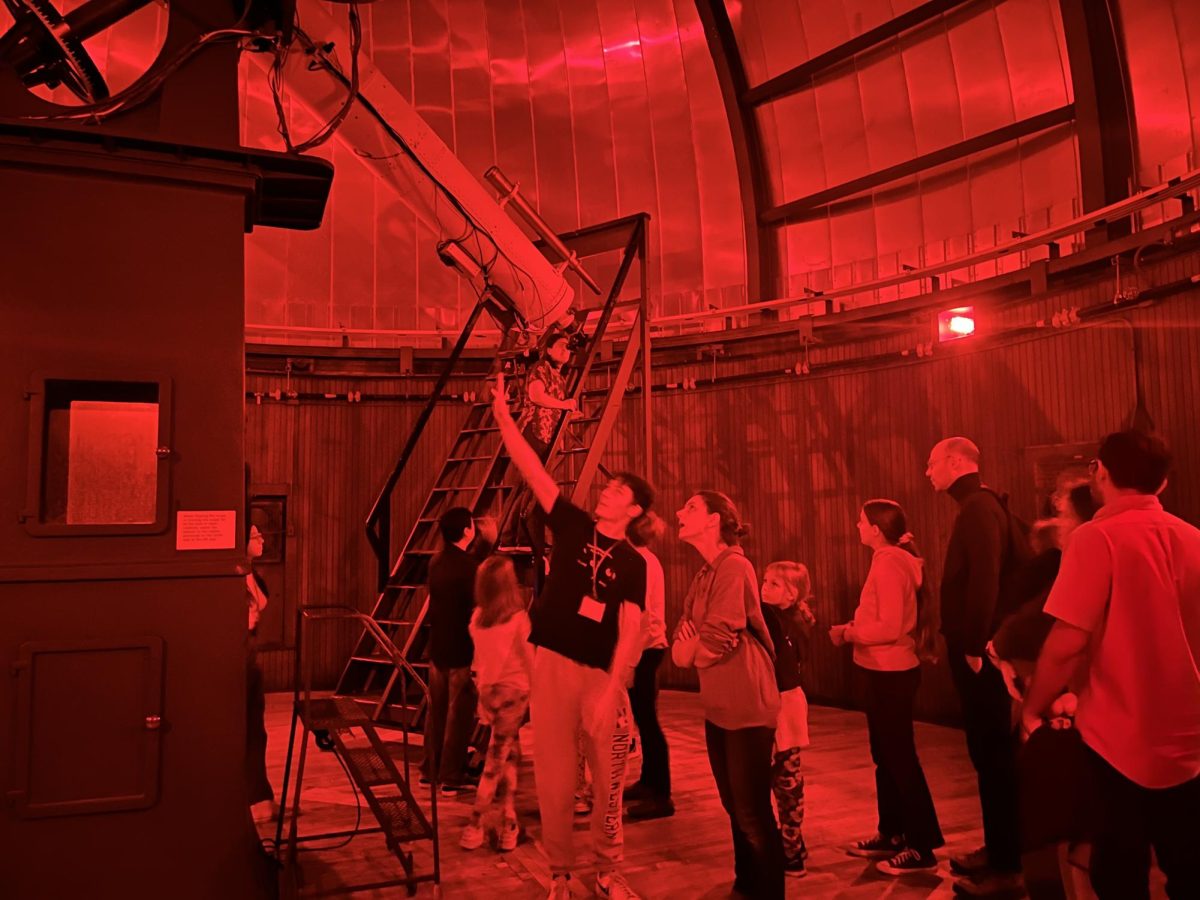 Faculty and their family members wait for a turn to view the moon through the Dearborn Observatory telescope.