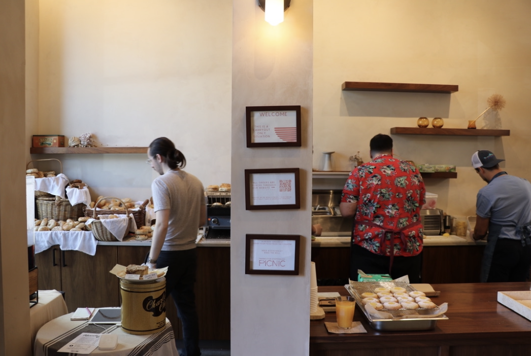 Co-owner Eric Kogan and fellow Mensch’s employees assemble customers’ open-faced bagel sandwich orders. The pop-up currently shares its space with Picnic on weekend mornings. 