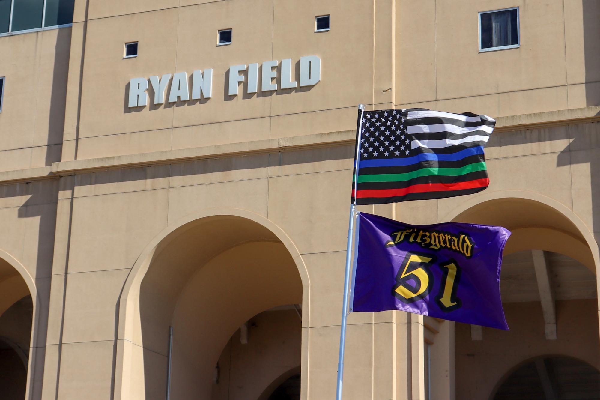 Flags are waved in front of a Ryan Field sign.