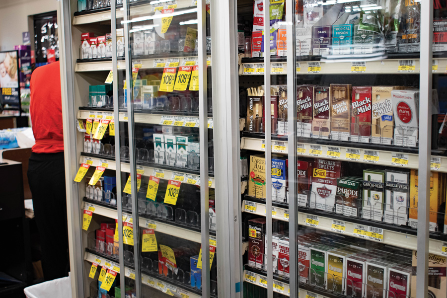 A store shelf lined with boxes of cigarettes.