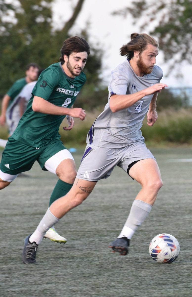 Junior midfielder Collin McCamy dribbles the ball away from a Green Bay defender.
