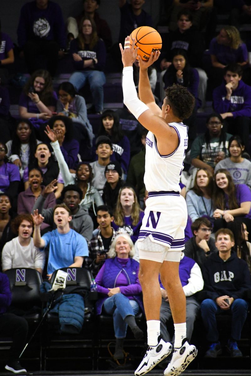 A player in a white and purple basketball uniform makes a shot.