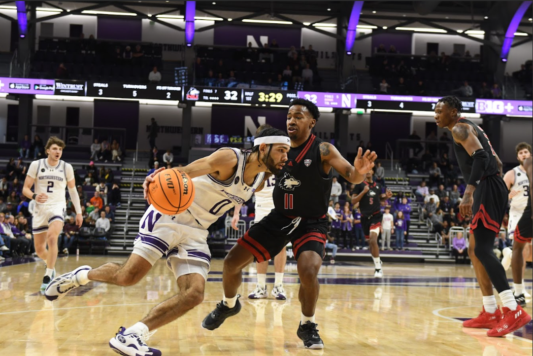 Graduate student guard Boo Buie dribbles baseline against Northern Illinois guard David Coit. Buie notched a team-high 23 points in Northwestern’s 89-67 win over the Huskies Monday.