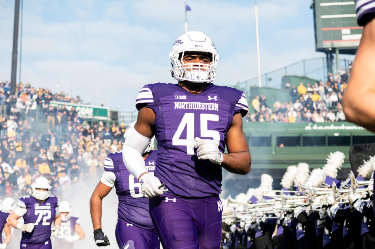 A football player in purple and white runs onto the field.