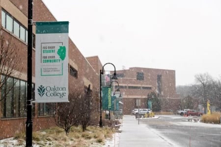 A few buildings at Oakton College with snow falling.