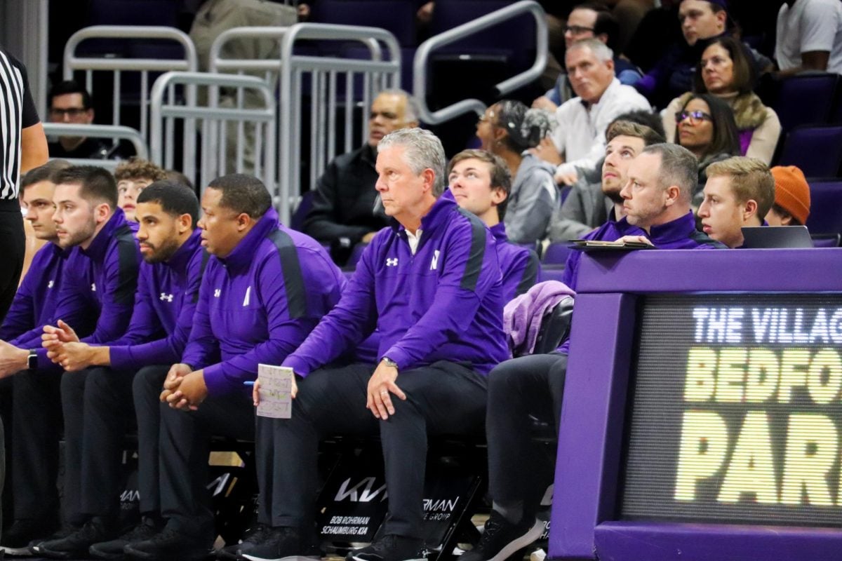 Northwestern special assistant to the head coach Brian James (center) sits on the sidelines during the Wildcats exhibition win over McKendree. 