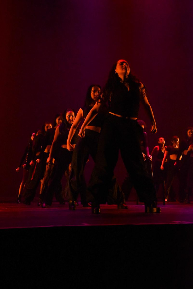 Dancers dressed in black stand in a line.