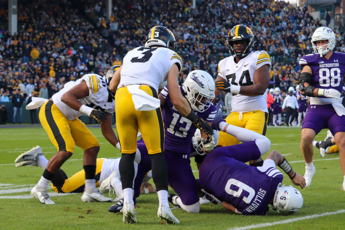 Junior quarterback Brendan Sullivan goes down following an Iowa tackle. In their loss to Iowa at Wrigley Field, Northwestern’s offensive struggles were on full display. 