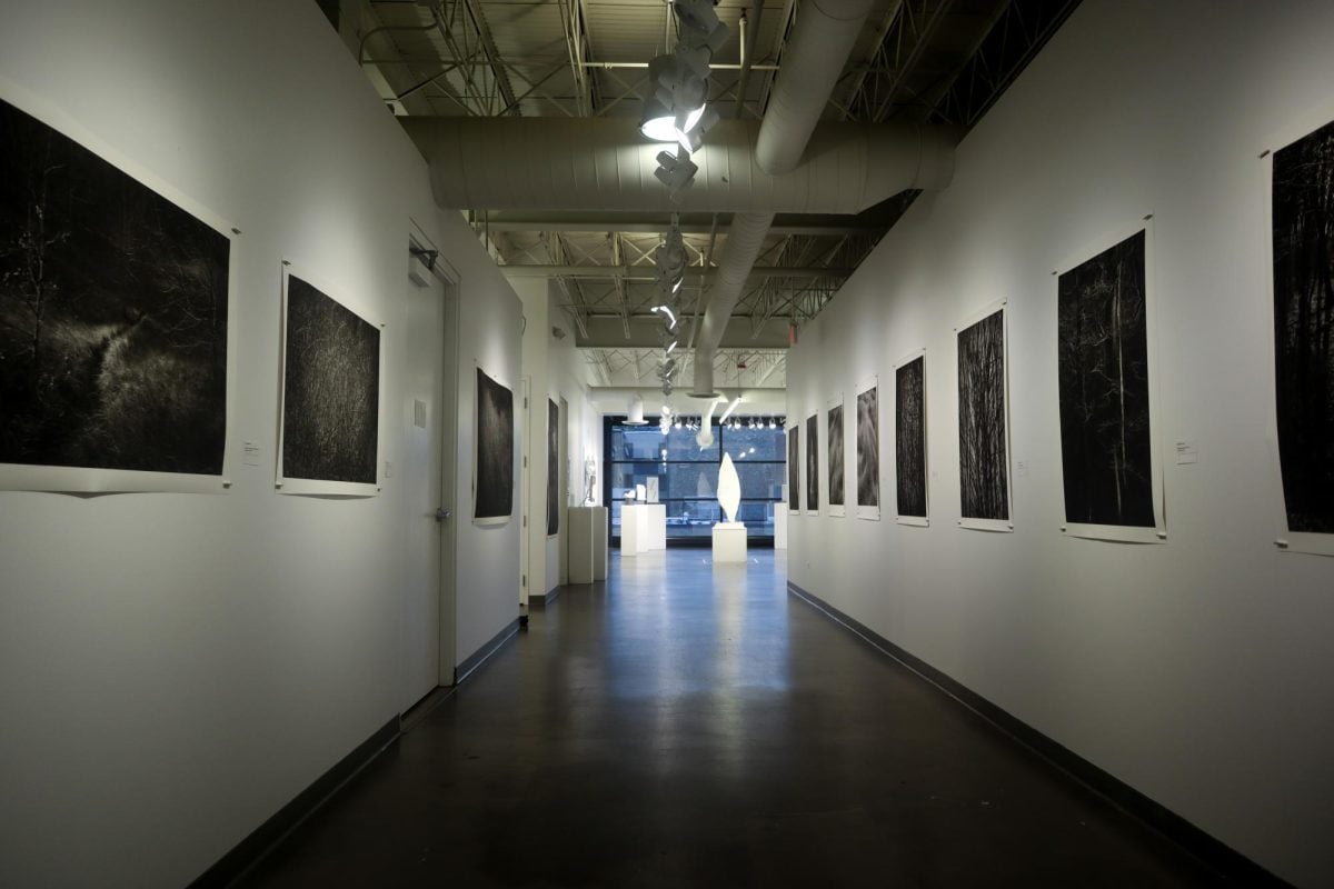 Portraits hang on the walls along a dim hallway.