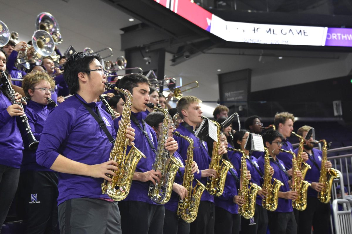 People in purple shirts play saxophones.