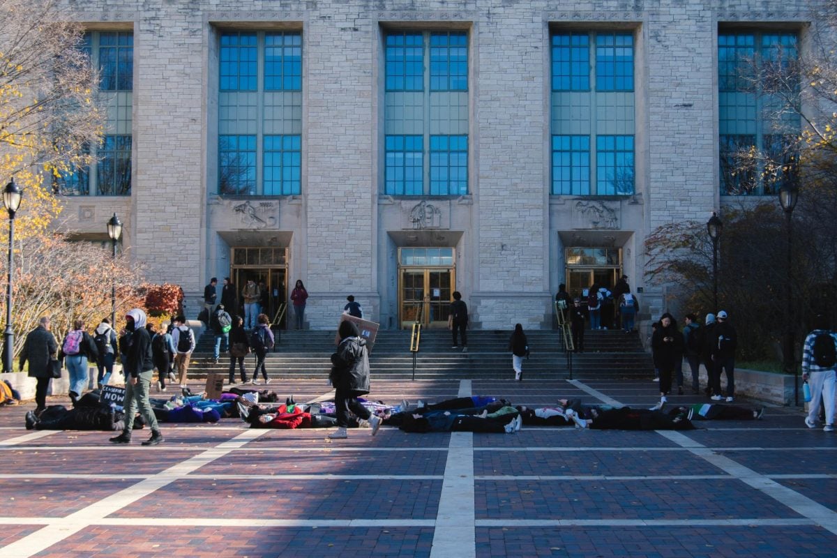Student protesters lay in front of the Technological Institute Thursday morning. Students walking to and from class stepped around or over the protesters, while some stopped to observe or film the event.