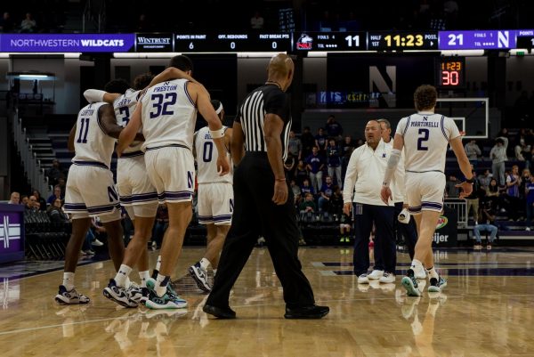 Two players in white jerseys help their teammate walk off the court.